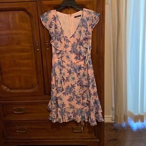 Floral print pink background with blue floral flowers. Zips in back .